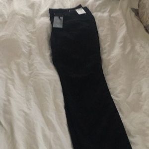 NEW. High rise black jeans. Ripped at knee